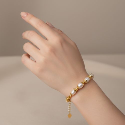 A gold-plated bracelet featuring irregular white baroque pearls set in gold-toned metal links, with a lobster clasp and an adjustable extender chain with a heart-shaped tag, shown on a plain white background.