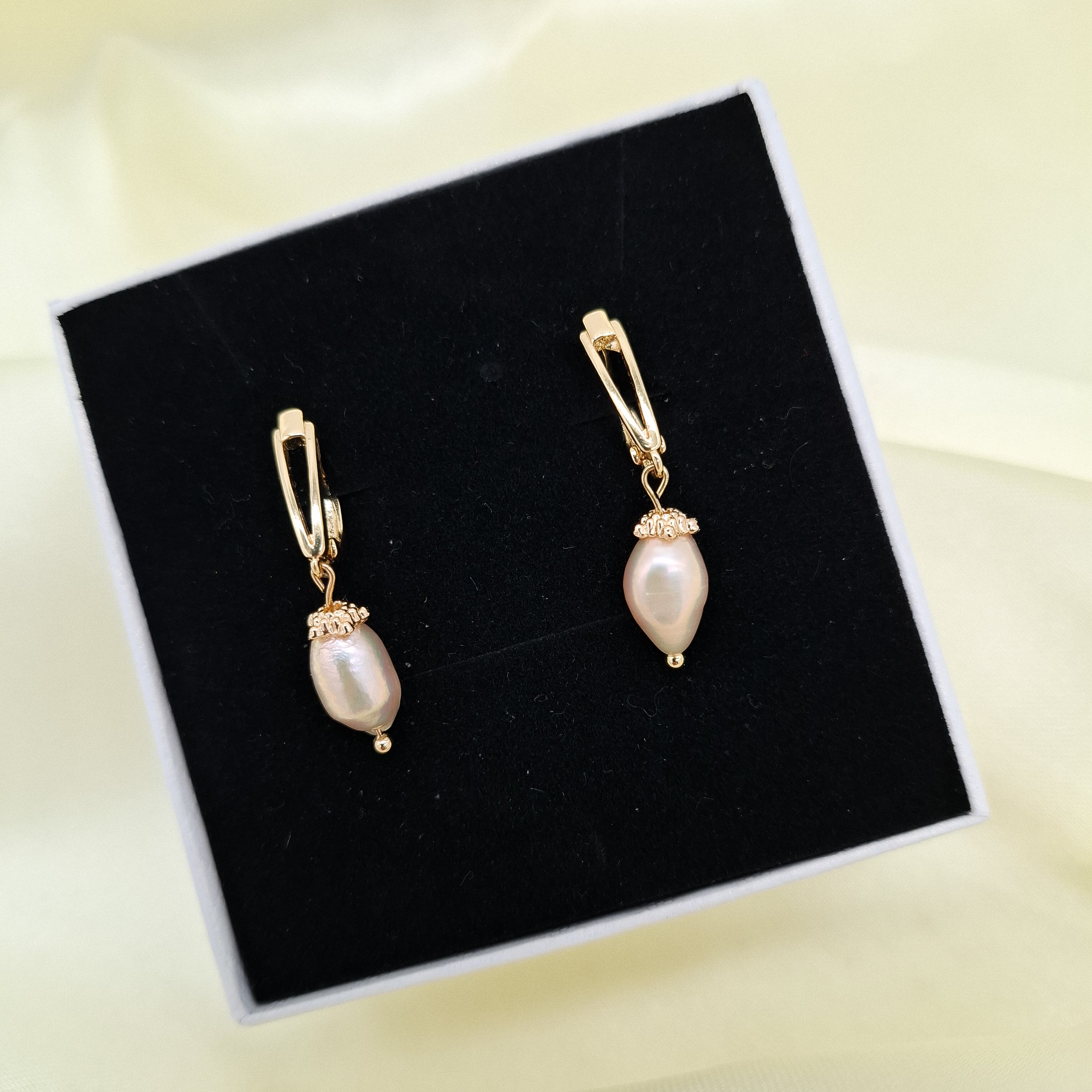 Bring vintage-inspired sophistication to your style with these detailed drop earrings. Featuring genuine freshwater pearls set under ornate textured bead caps and suspended from secure gold leverback closures, these earrings are 100% handcrafted in the Philippines by local artisans. Crafted with high-grade non-tarnish materials, they deliver long-lasting brilliance without fading.
